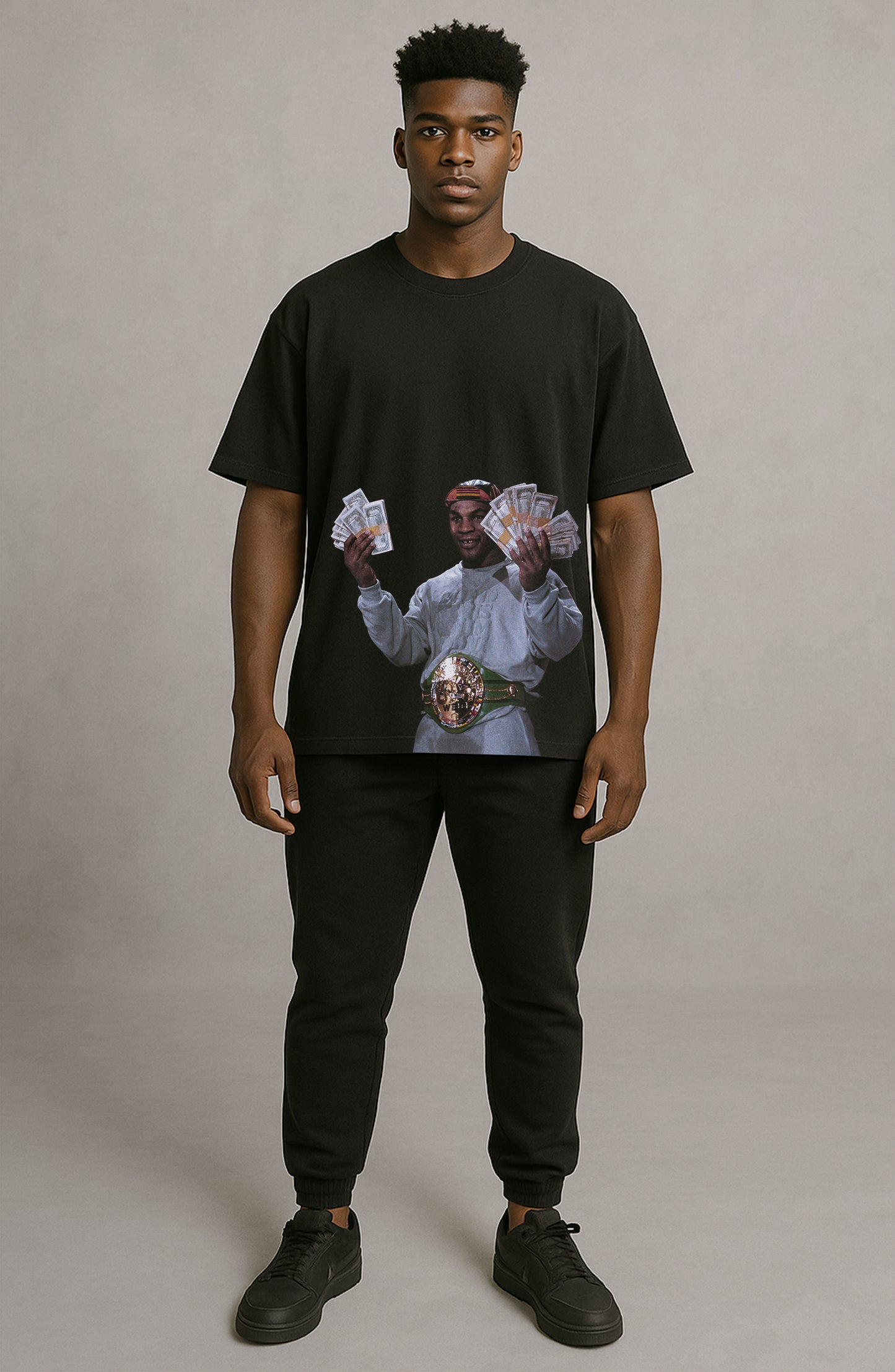 Person wearing a black t-shirt with a graphic design on a plain background